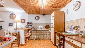 A kitchen with wooden cabinets, a tiled floor, and a wooden ceiling. - Room 'Parfum De Soleil' with Shared Terrace, Shared Garden and Wi-Fi (Bédoin)