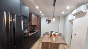 Una cucina moderna con isola centrale, elettrodomestici neri e pavimento in legno.