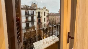 A balcony with a view of historic buildings and a cloudy sky. - Rooms Consell de cent (Barcelona)