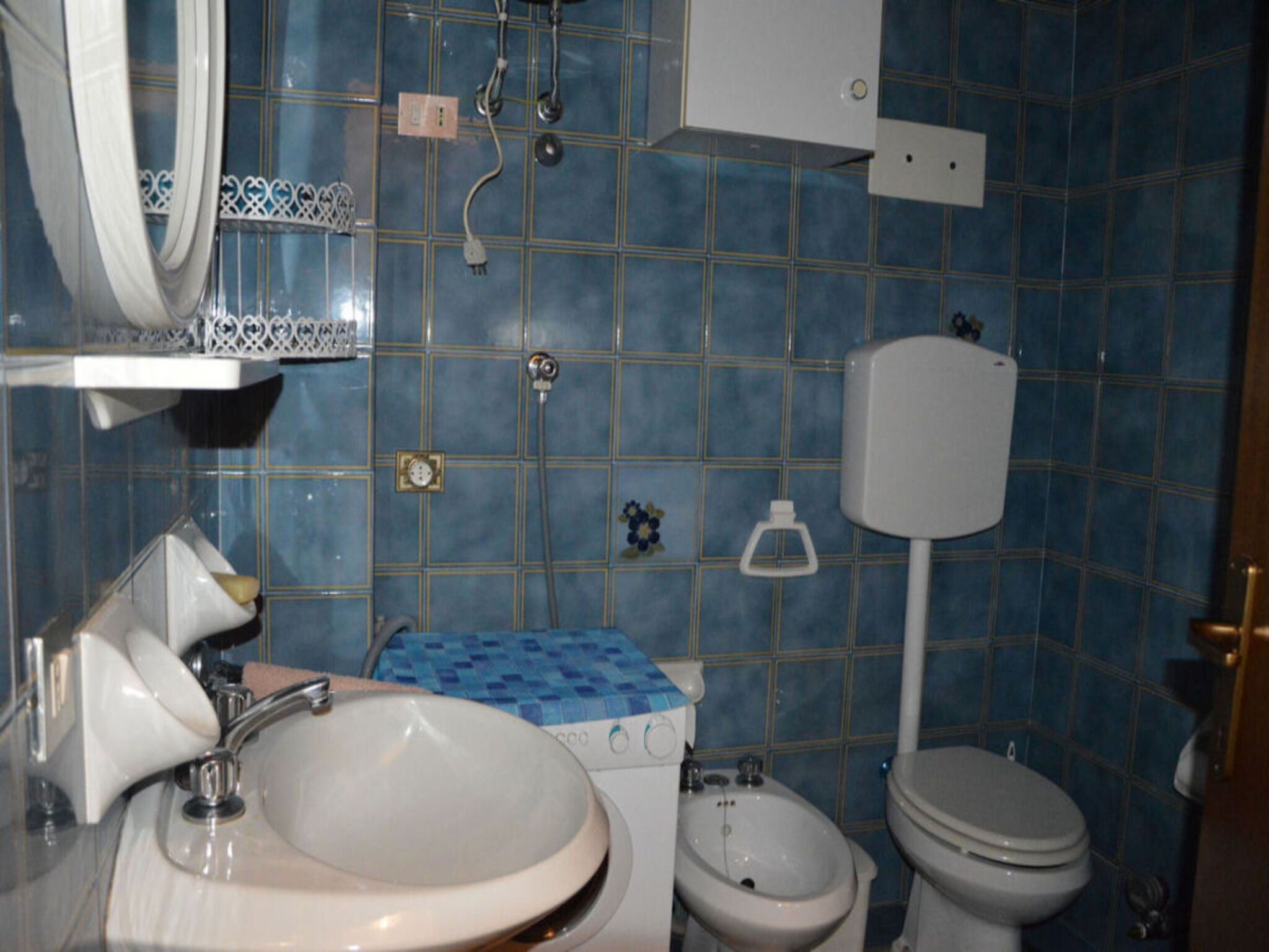 A bathroom with a sink, toilet, bidet, and a shower.