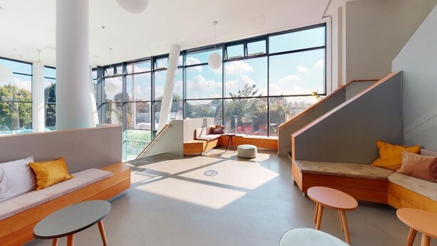 Un intérieur spacieux et moderne, doté de grandes fenêtres, d’un escalier et d’espaces de détente confortables.
