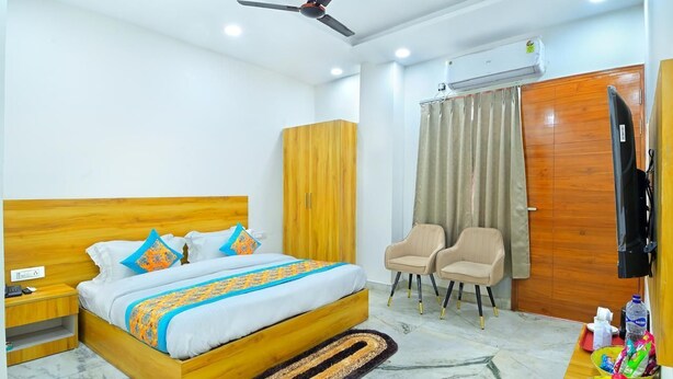 Un dormitorio con una cama de madera, dos sillas, un armario y un televisor.