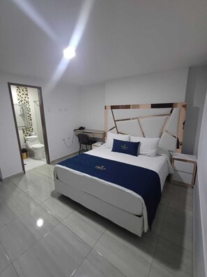 Une chambre moderne avec un lit, des tables de chevet, un bureau et un miroir.