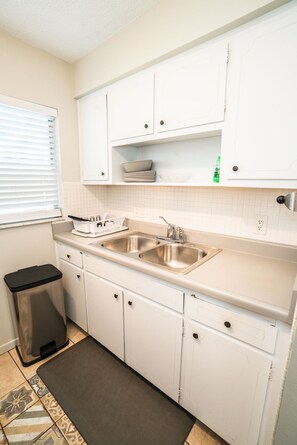 Een koelkast, een microgolfoven, kookgerei, borden en bestek