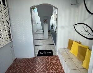 A hallway with a welcome mat, a doormat, and a bench with cushions. - Land and relax:  5 minutes away from the airport (Carolina)