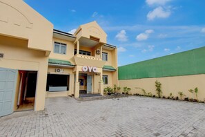 A building with a sign 'OYO' and a paved courtyard. - OYO 95136 Jec Plumbon Homestay Syariah (Banguntapan)