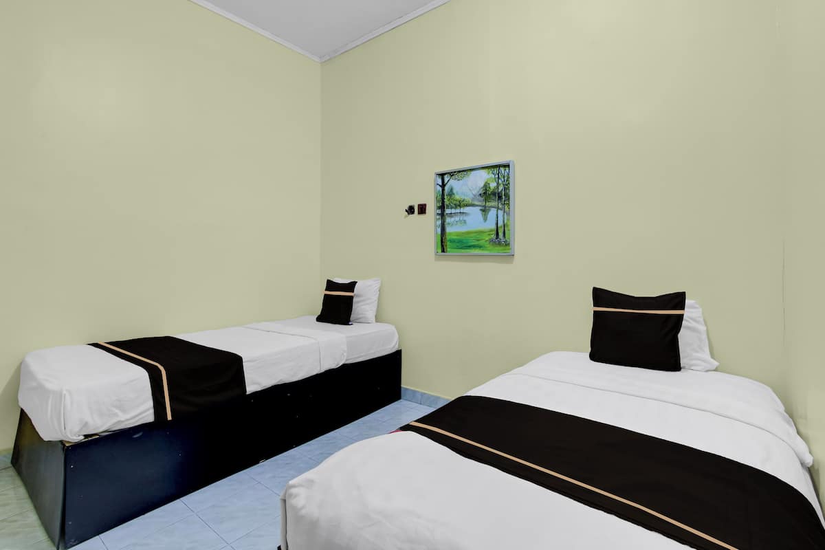 Una habitación con dos camas, cada una con una colcha blanco y negro y almohadas a juego.