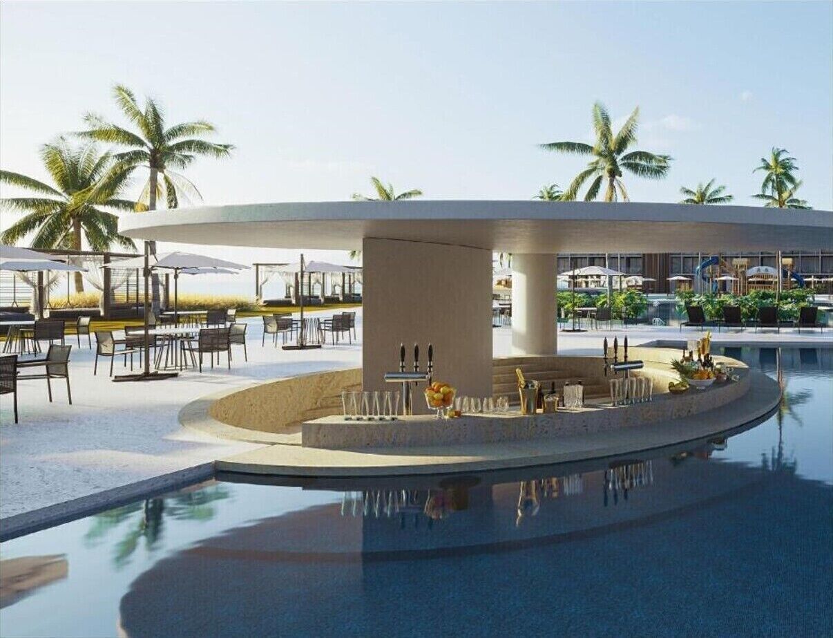 A poolside area with a bar, lounge chairs, and palm trees.