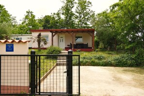 Um pequeno edifício térreo com varanda, porta e janela.