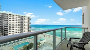 Ein Balkon mit Blick auf das Meer und einen Pool.
