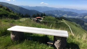 A bench overlooking a mountainous landscape with a clear sky.
