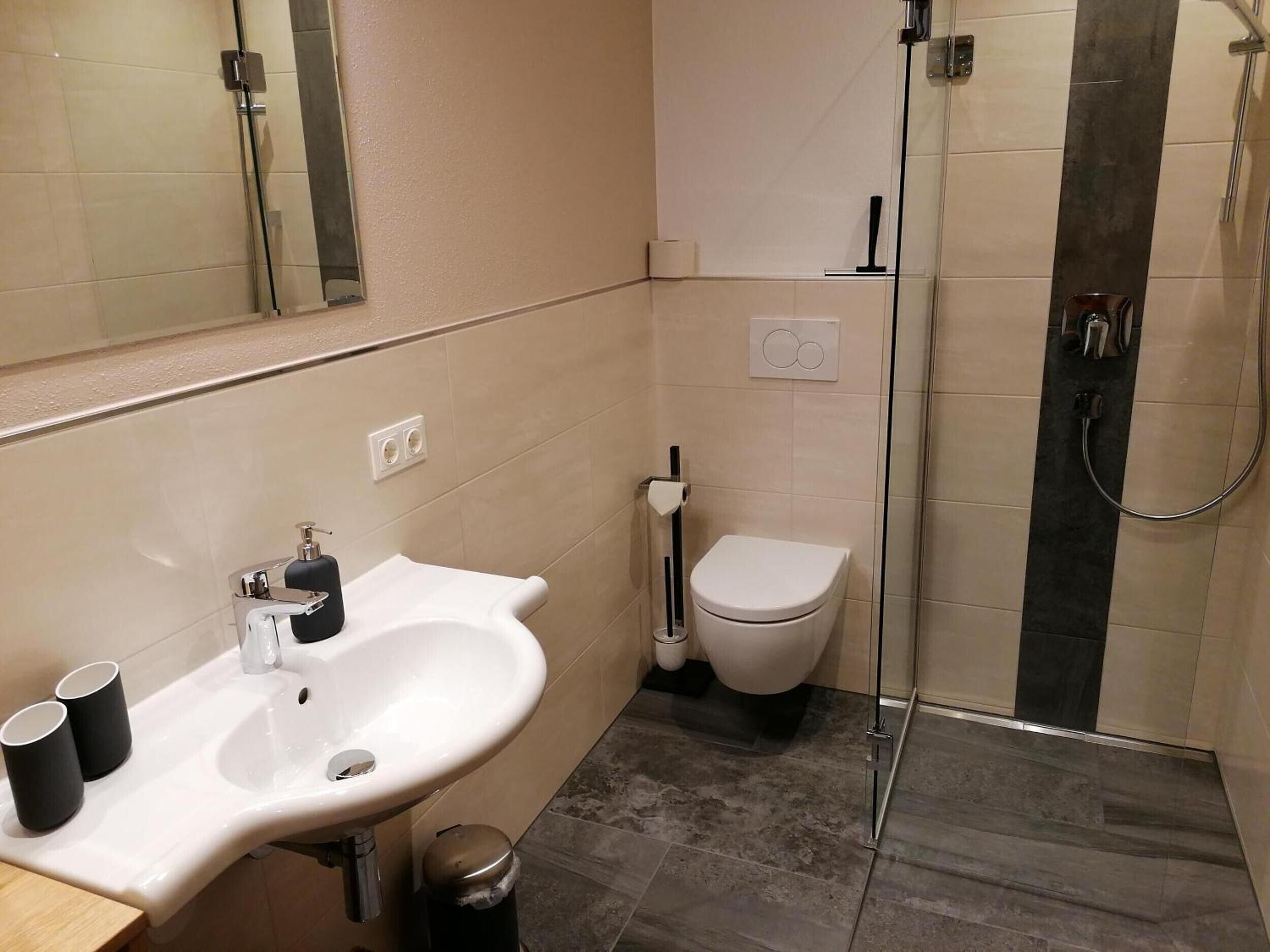 Un baño con lavamanos, inodoro y ducha.
