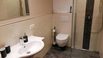 Ein Badezimmer mit Waschbecken, Toilette und Dusche.