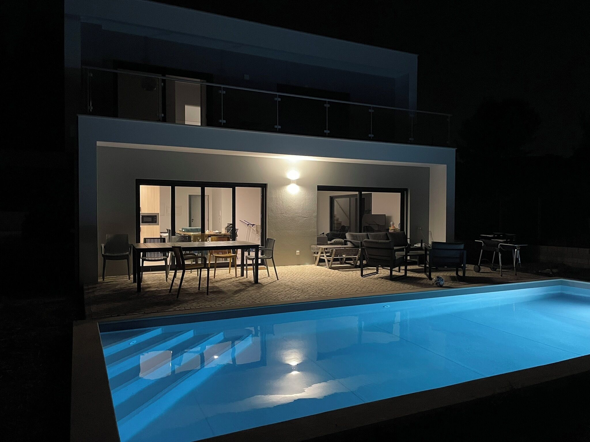 A modern house with a swimming pool, a dining area, and a living room with a fireplace.