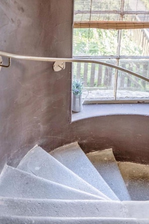 A concrete staircase with a metal handrail leading to a window overlooking a wooden deck. - Sleeps 5 | 2 Bedrooms | Hawick (Hawick)