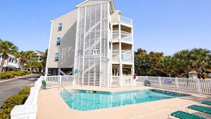 Un hôtel avec une piscine, une clôture blanche et un panneau indiquant qu’il est interdit de plonger.