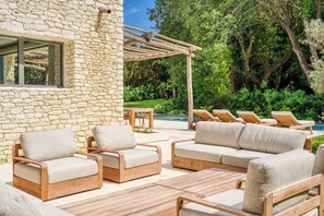A stone building with outdoor seating and a pergola.