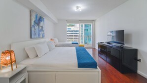 A modern bedroom with a large bed, a TV, and a balcony with a city view. - Brickell Bay 1720 (Miami)