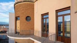 A multi-story building with a brick facade, large windows, and a balcony with a metal railing. - Residenza 2 Venti-Intera by Ortigia Apartments (Syracuse)