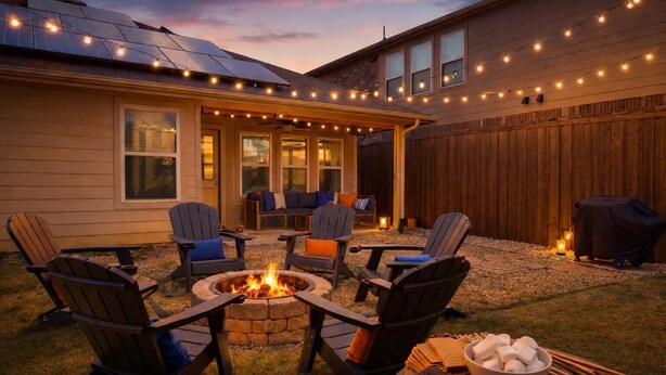 Ein Garten mit Feuerschale, Sitzgelegenheit und Grill.