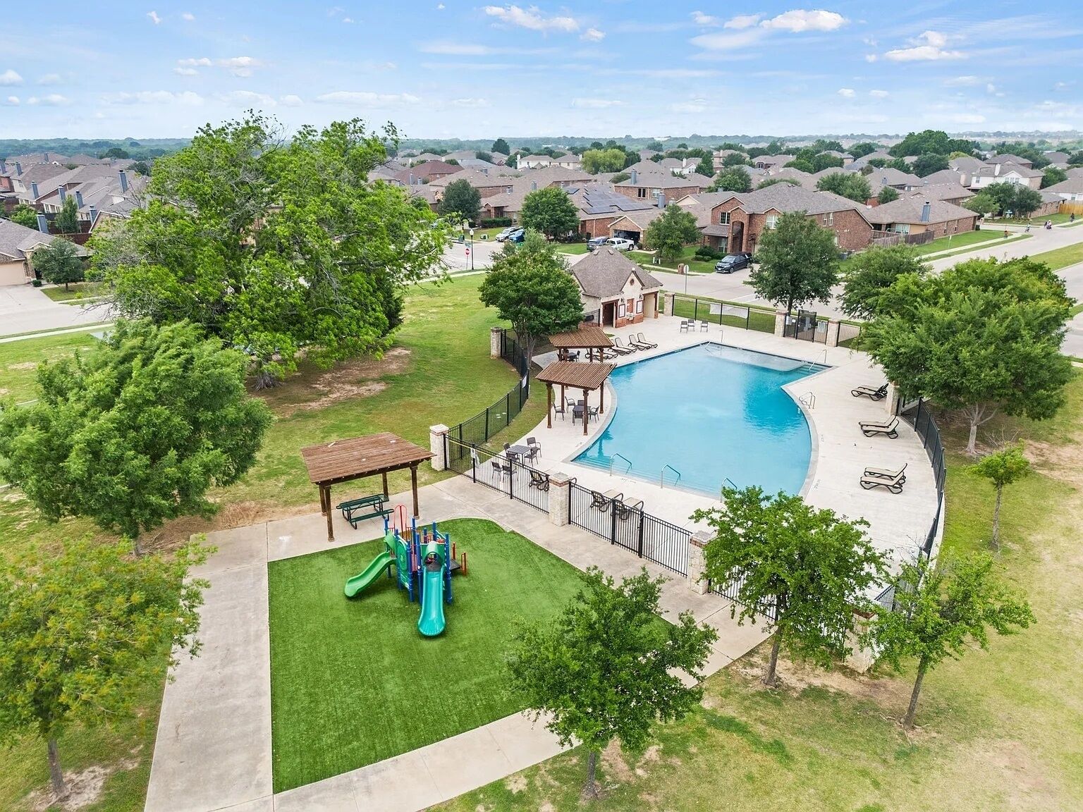 Zona residencial con piscina, área de juegos infantiles y un pabellón.