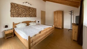 A wooden-framed bedroom with a bed, a wardrobe, and a coat rack. - Holiday Home Plattenstein with Private Terrace, Garden, Sauna, Wi-Fi and BBQ (Kirchberg im Wald)