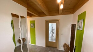 A hallway with a wooden ceiling, a door with a glass panel, and green walls. - Holiday Home Plattenstein with Private Terrace, Garden, Sauna, Wi-Fi and BBQ (Kirchberg im Wald)