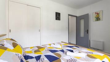 Une chambre à coucher avec un lit, une porte et un tableau accroché au mur.