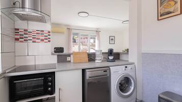 A compact kitchen with a built-in toaster oven, a dishwasher, and a washing machine.
