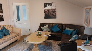 A living room with two sofas, a coffee table, and wall-mounted pictures.