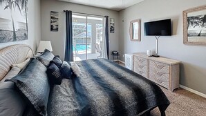 A bedroom with a bed, a ceiling fan, a TV, a dresser, and a view of a pool. - Star Villa: Private Pool with 24/7 Support! (Davenport)