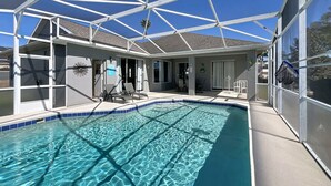 A swimming pool with a glass enclosure, lounge chairs, and a covered patio area. - Star Villa: Private Pool with 24/7 Support! (Davenport)