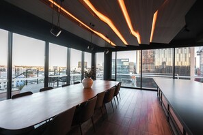 Ein moderner Konferenzraum mit einem langen Tisch, Stühlen und einem großen Fenster mit Blick auf die Stadt.