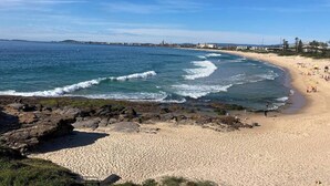 A beach with a rocky shoreline, sandy beach, and ocean waves. - City Perch Escape Sweeping Penthouse style Haven (Wollongong)