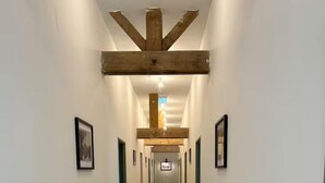 A long, narrow hallway with wooden flooring and white walls. - Gîte La Garenne (La Ferté-Saint-Aubin)