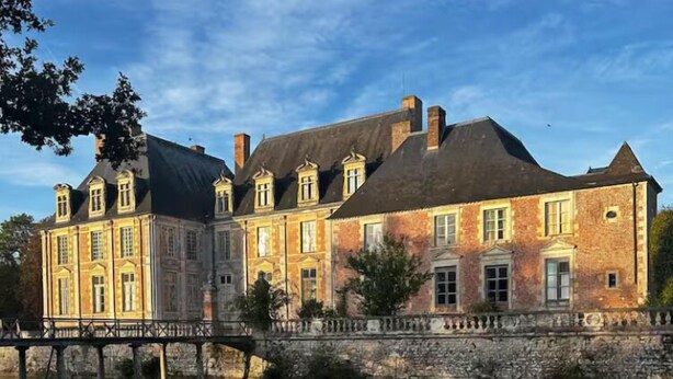 A large, historic building with a symmetrical facade, a central tower, and a reflection in the water. - Gîte La Garenne (La Ferté-Saint-Aubin)