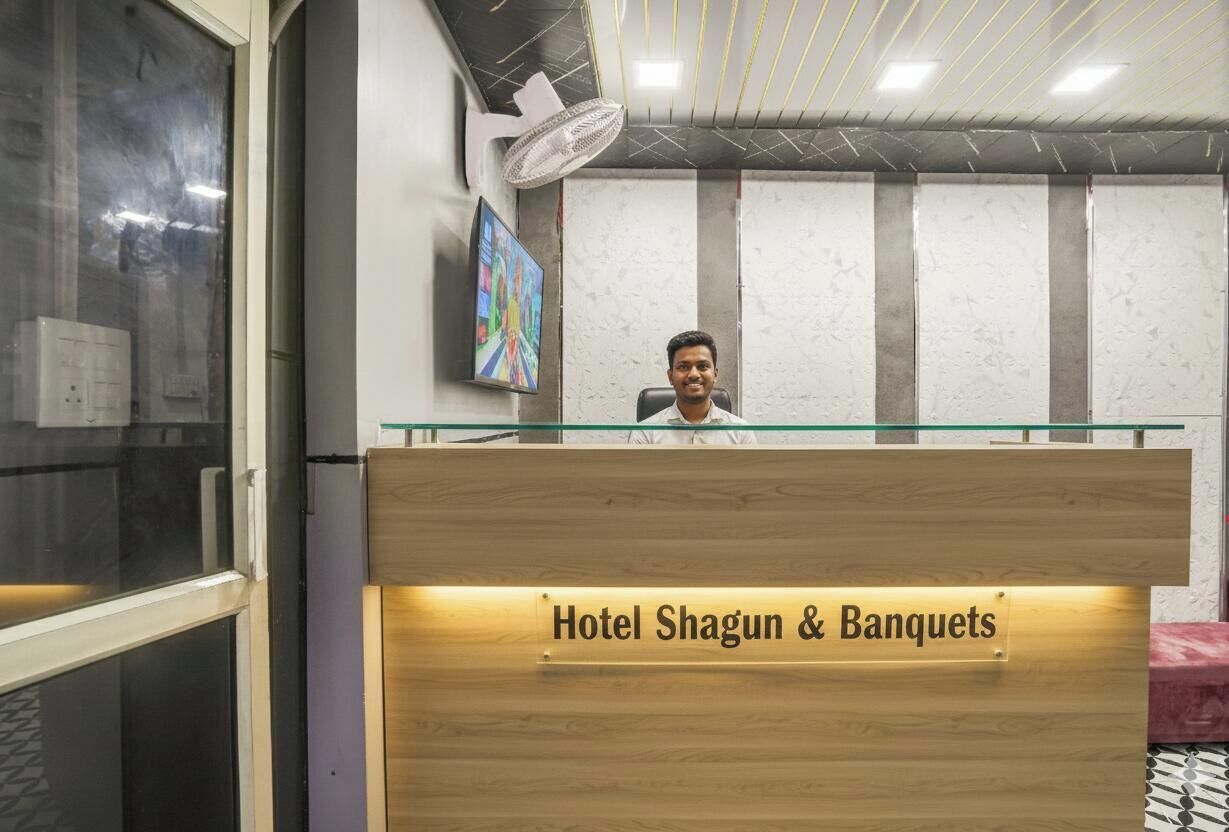 Un mostrador de recepción con un cartel que dice "Hotel Shagun & Banquets".