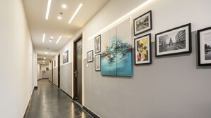 Un corridoio con opere d'arte incorniciate alle pareti e una porta in fondo.