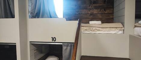 A bunk bed room with wooden walls and a number '10' on the lower bunk.