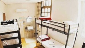 A bunk bed room with a desk and chair, a window with curtains, and a wall-mounted air conditioner. - PORTO ALEGRE HOSTEL BOUTIQUE (Porto Alegre)
