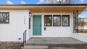 A single-story house with a green door, white siding, and a number "1305" on the wall. - Billings Homesteader: Near Hospital, Trails, Stores, and Entertainment (Billings)