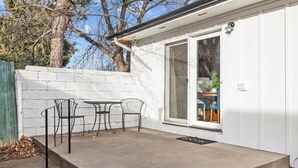 A small, white building with a concrete patio, two metal chairs, and a table. - Billings Homesteader: Near Hospital, Trails, Stores, and Entertainment (Billings)