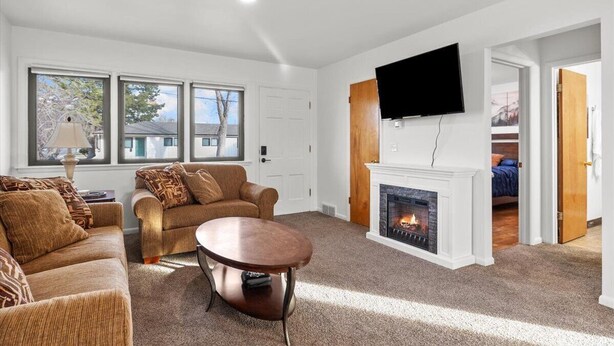 A living room with a fireplace, a television mounted on the wall, and a sofa. - Billings Homesteader: Near Hospital, Trails, Stores, and Entertainment (Billings)