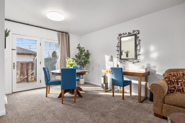 Un coin repas avec une table ronde, des chaises bleues et un plancher en bois.