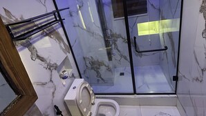Ein modernes Badezimmer mit einer Duschkabine, einer Toilette und einem Waschbecken.