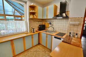 A kitchen with a window, a coffee maker, a sink, and a stove. - Holiday home with private sauna and garden (Jaroslawiec)
