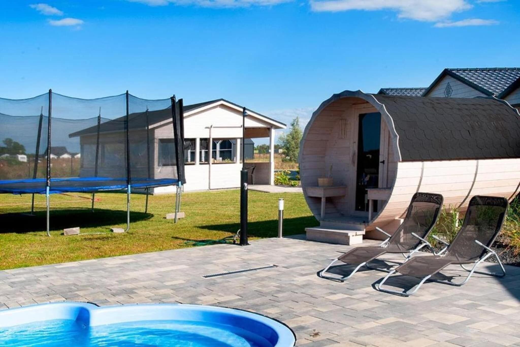Ein Poolbereich mit Trampolin, Liegestühlen und einer Holzkonstruktion mit gewölbtem Dach.