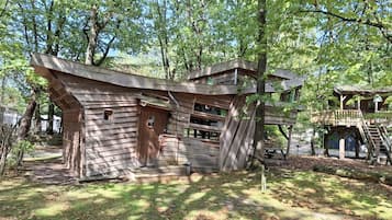 Eine rustikale Holzhütte mit geneigtem Dach, Holzwänden und einer kleinen Veranda.