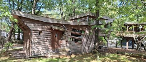 A rustic cabin with a sloped roof, wooden walls, and a small porch.