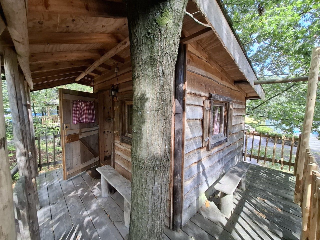 Eine Holzhütte mit Veranda, Bank und Tür.